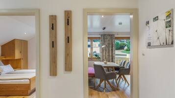 Una habitación moderna con una cama, un armario de madera y una zona de comedor con mesa y sillas.