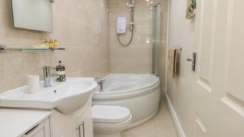 A modern bathroom with a sink, toilet, and shower.