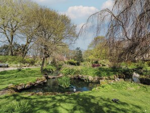 A serene park with a pond, trees, and a bench. - Apartment 4 (Lytham St. Anne's)