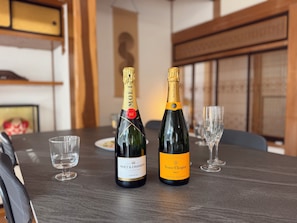 Two bottles of Veuve Clicquot Brut champagne on a table with two empty glasses.