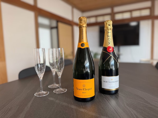 Two champagne bottles and three empty glasses on a table.