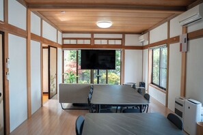 A conference room with a large table, chairs, a television, and windows with a view of greenery. - To Kurobe Dam, Hakuba, and Tateyama! Max. 11 people/ 4 min. walk from station/ 3 parking spaces/ Self-catering OK Large kitchen with Wi-Fi. Ideal for large groups or as a base for family vacations! Long-term stay welcome (大町市大町)