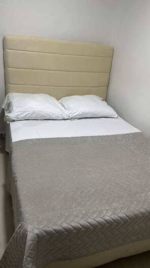 A single bed with a headboard, white bedding, and a grey quilted blanket. - Room-las3p Acogedor Apartamento Cerca de (Santo Domingo)