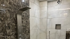 A bathroom with a shower, toilet, and a small sink.