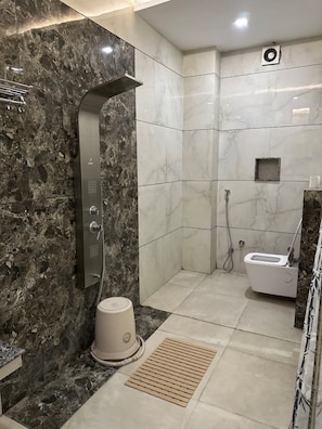 A bathroom with a shower, toilet, and a small sink.