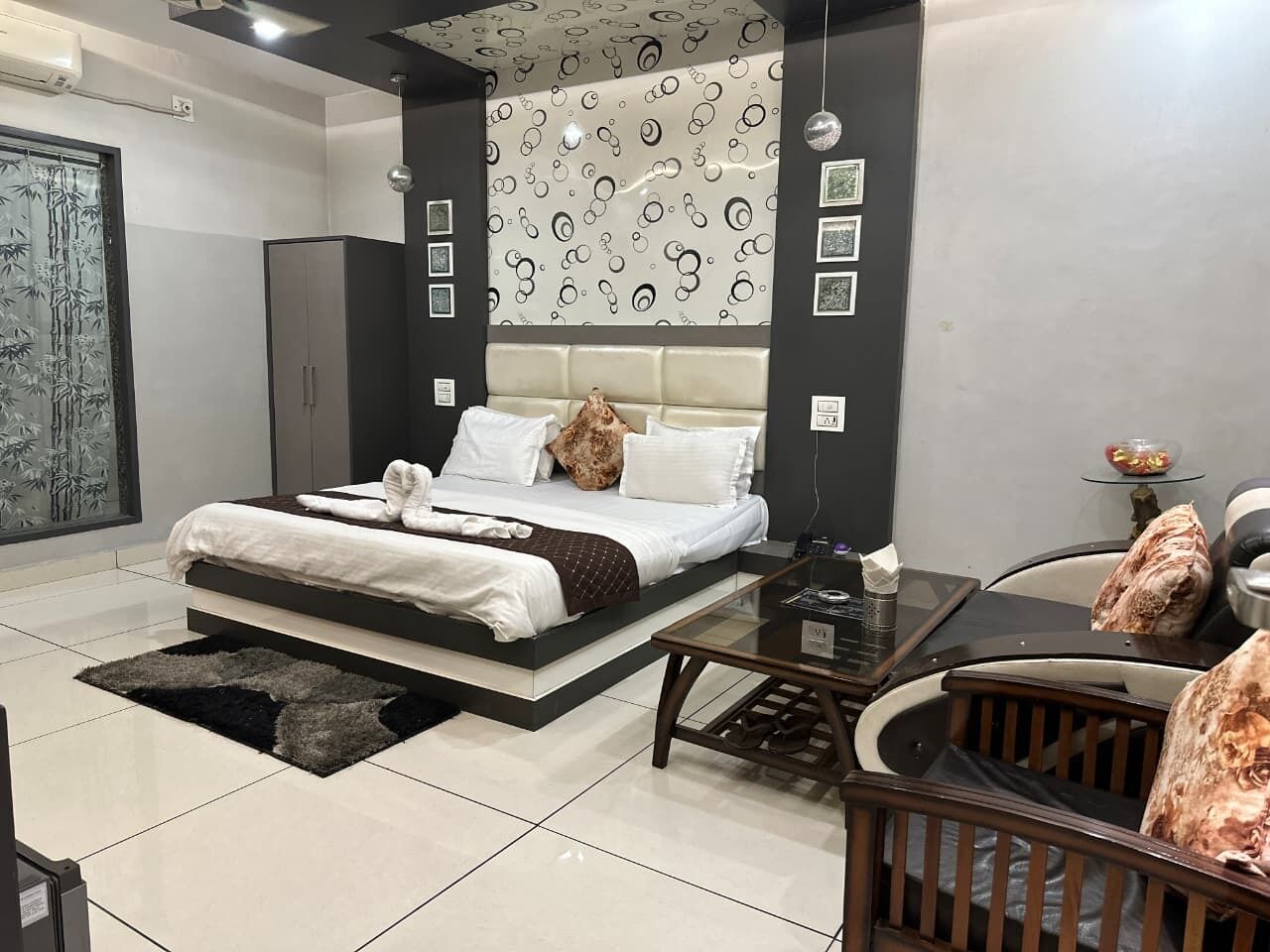 A modern bedroom with a bed, bedside table, and a glass coffee table.