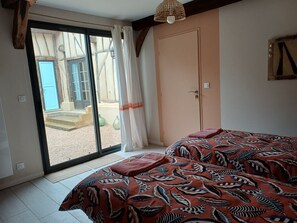 A bedroom with a bed, a door, and a view through a window. - Gîte le Bergerayre 6 people Swimming pool/Campagne 4-star accommodation (ST GRIEDE)