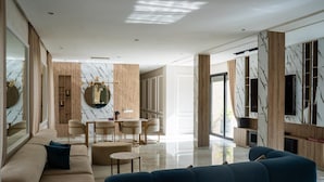 Una sala de estar moderna con un sofá, una mesa de comedor y un televisor.
