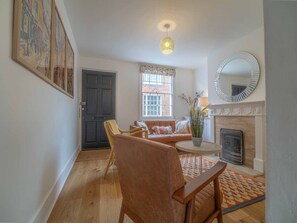 A living room with a sofa, chairs, a fireplace, and a large mirror. - City Centre Cottage | Canterbury  | Garden & Views (Kent)