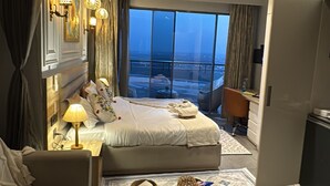 Une chambre d’hôtel avec un lit, un canapé, une table basse et une vue sur le paysage urbain.