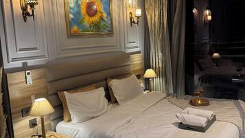 Un dormitorio moderno con una cama grande, lámparas de noche, un ventilador de techo y un cuadro de girasoles.