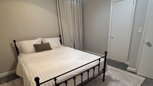 A bedroom with a bed, a ceiling fan, a door, and a carpeted floor. - Peaceful Atlanta Stay.
Walk to Lake & Trail. Cozy & Quiet (Tucker)