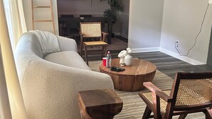 A living room with a sofa, wooden coffee table, and a chair. There is a ladder and a plant in the background. - Peaceful Atlanta Stay.
Walk to Lake & Trail. Cozy & Quiet (Tucker)