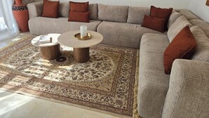 A living room with a beige sofa, two round coffee tables, a patterned rug, and decorative pillows. - Villa Gan Atlas - Luxury, pool, 7 suites, 14 pers. quiet & nature Marrakech (Marrakech)