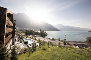 Un hôtel doté d’une piscine, d’un espace extérieur aménagé et offrant une vue sur un lac et des montagnes.