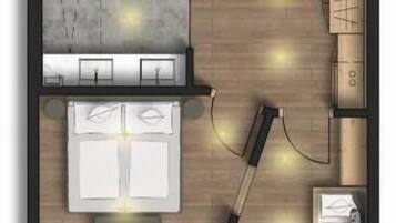 Ein Hotelzimmer mit Bett, zwei Nachttischen, Schreibtisch, Stuhl, einer kleinen Sitzecke und einem runden Tisch mit vier Stühlen.