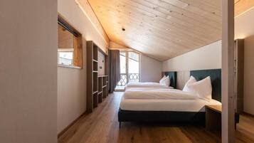 A bedroom with a wooden ceiling, a bed, a nightstand, and built-in shelving.