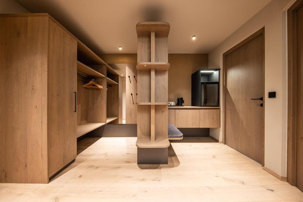 A modern interior with wooden cabinetry, a central column, and a kitchen area.