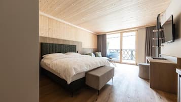 Een slaapkamer met een bed, een bureau, een stoel en een balkon.