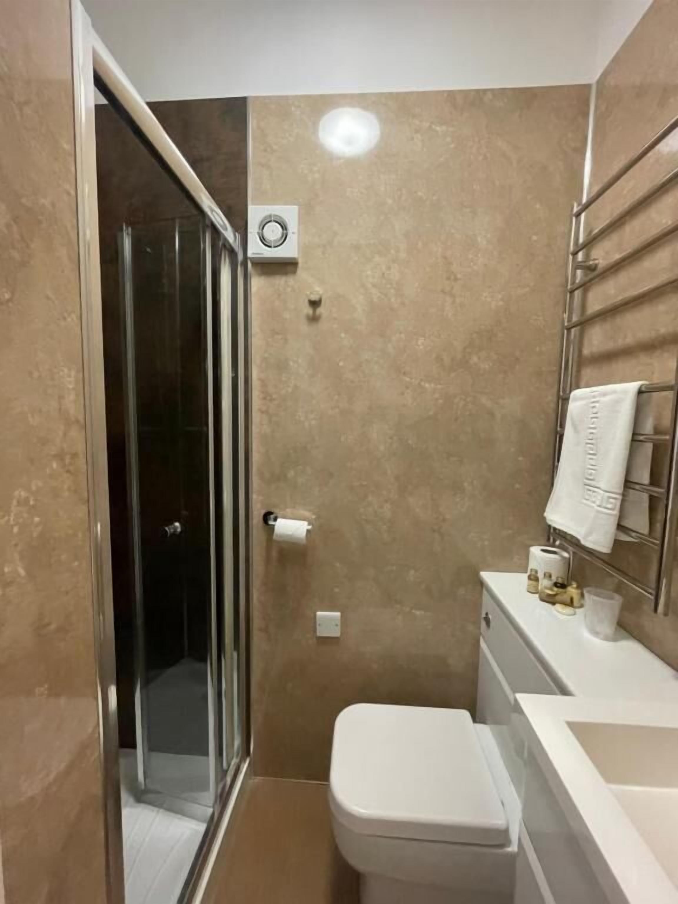A bathroom with a shower, toilet, and sink.