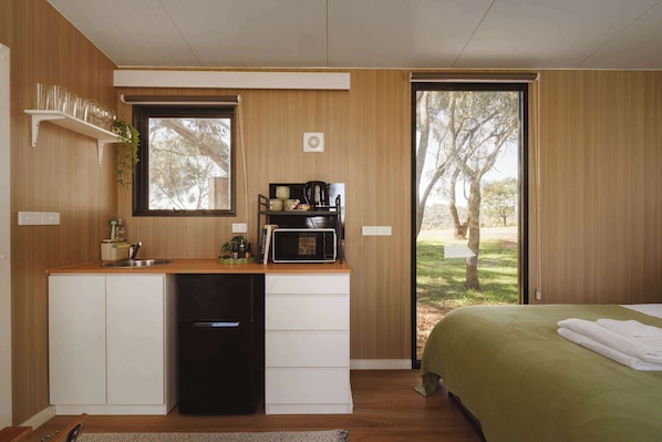 A compact kitchenette with a sink, a coffee maker, and a microwave.