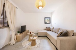 A modern living room with a sofa, a TV, a small table, and a decorative light fixture. -  Private Kornati House with Full Comfort.  Full Privacy, Pet-Friendly ! (Kornati)