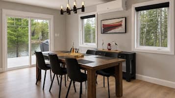 A dining area with a wooden table, black chairs, and a chandelier.