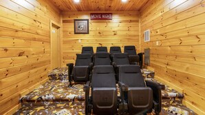 A wooden-paneled room with a 'MOVIE NIGHT' sign, rows of black chairs, and a patterned carpet. - Private 8BR Gatlinburg Cabin w Amazing Views (Gatlinburg)