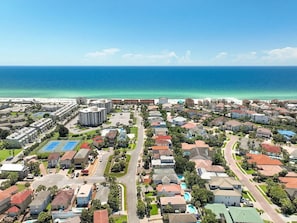 A coastal residential area with houses, a large building, and a clear view of the ocean. - Crystal Beach Home With Private Pool Walk to Beach (Destin)