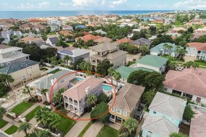 Un quartier résidentiel avec des maisons, une piscine et une vue sur l’océan.