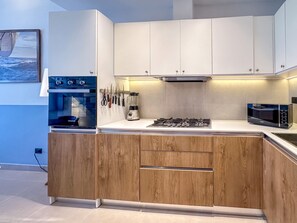 A modern kitchen with a built-in oven, gas stove, microwave, and knife rack. - Cocotal Penthouse 3 Bedroom Golf View (Punta Cana)