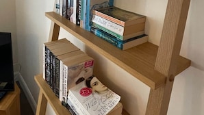 Ein Bücherregal mit Büchern und einer Blumenvase.