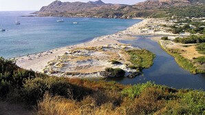 A coastal landscape with a beach, boats, and mountains. - Authentic stone house in the heart of a medieval village · sea 20 min away (Lama)