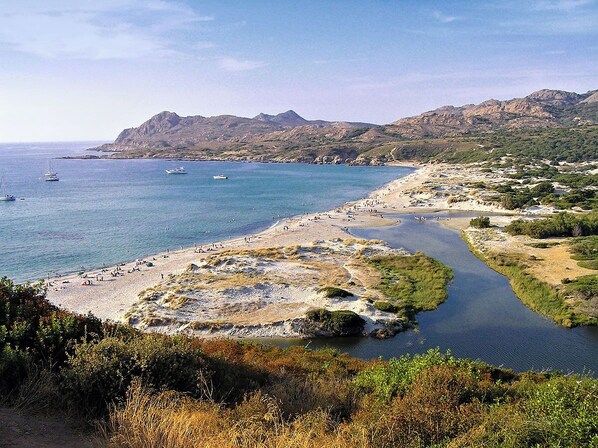A coastal landscape with a beach, boats, and mountains. - Authentic stone house in the heart of a medieval village · sea 20 min away (Lama)
