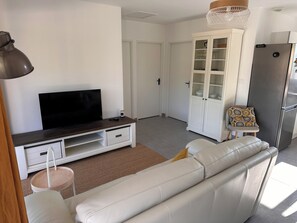 A living room with a sofa, TV, cabinet, and a refrigerator. - Ô Gorges-a 5-minute walk from the river and the Ardèche gorges (Vallon-Pont-d'Arc)