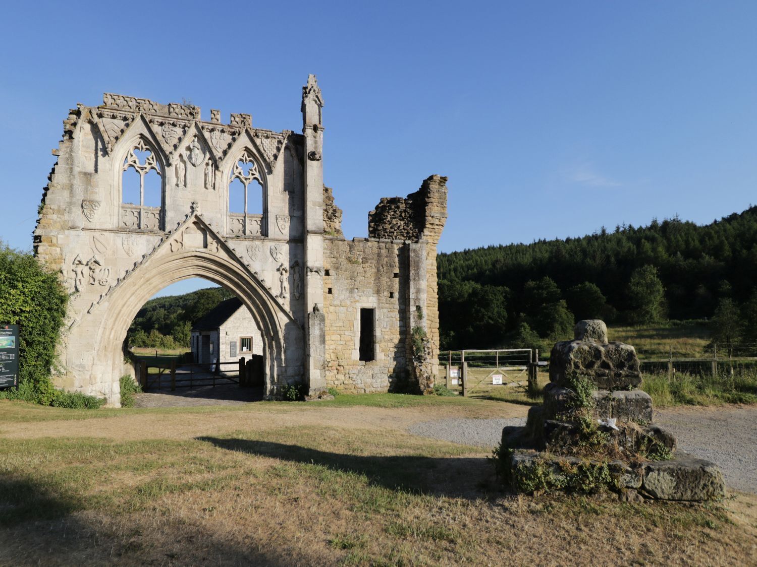 A historic stone archway leading to a building with a small entrance.
