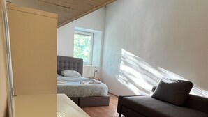 A modern room with a bed, a sofa, and a desk. - Vila Veselova (Ljubljana)