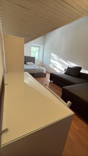 Una habitación moderna con una cama, un sofá y un escritorio.