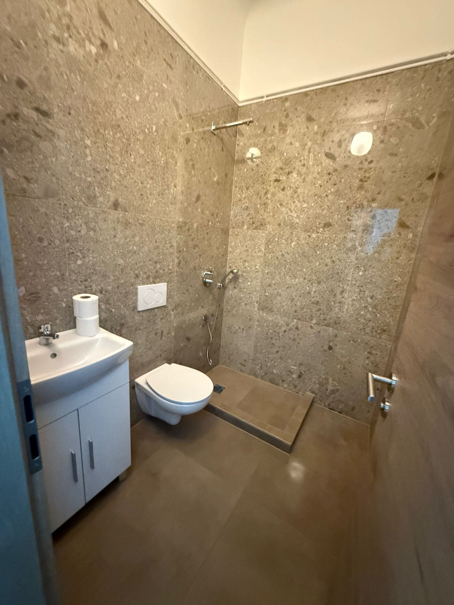 A bathroom with a shower, toilet, and sink.