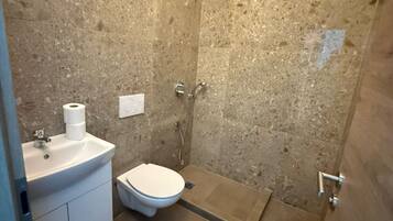 A bathroom with a shower, toilet, and sink.