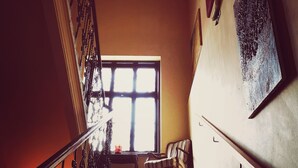 A staircase with a metal railing, a window, and a chair. - Vila Veselova (Ljubljana)