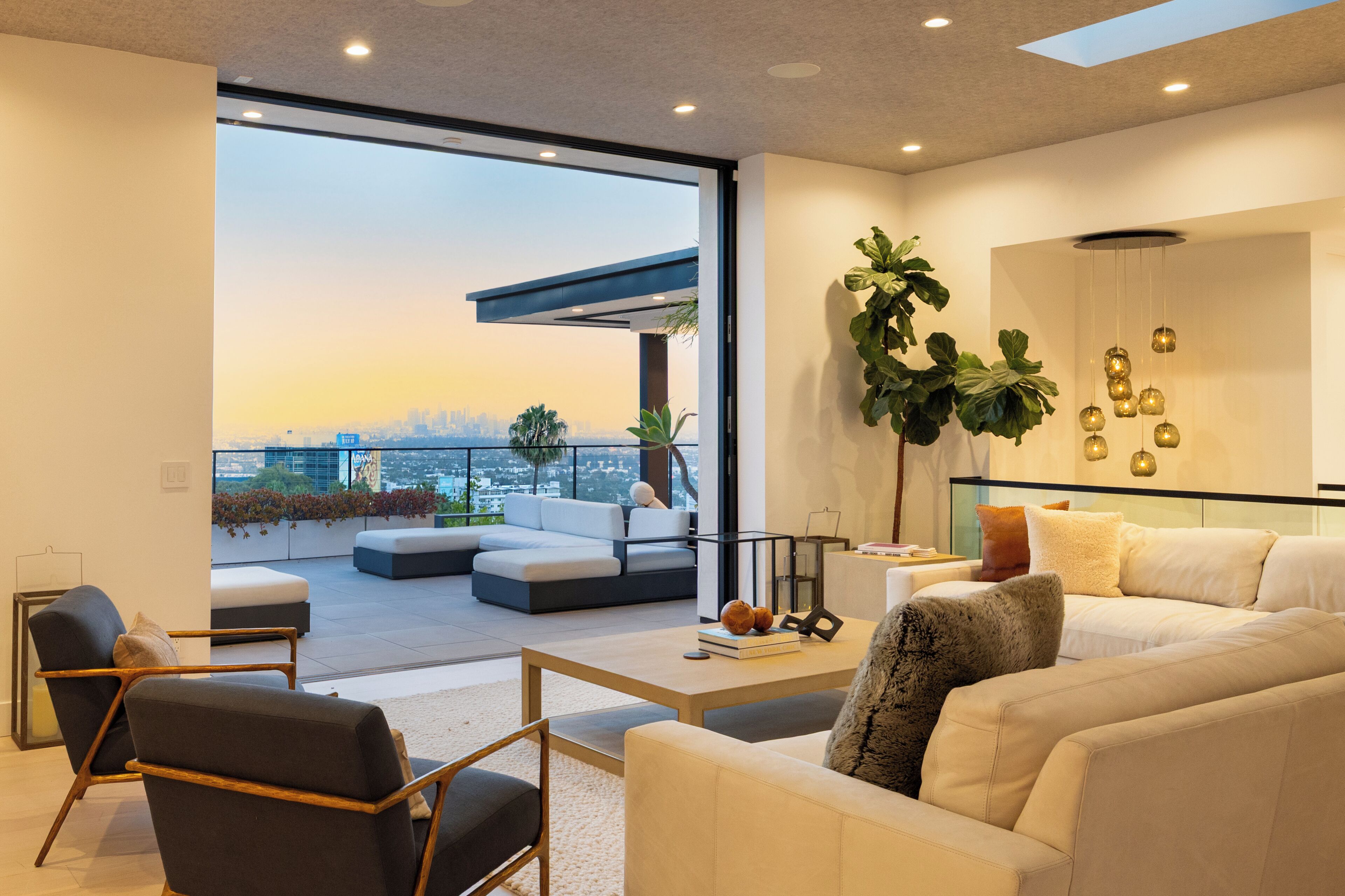 Un salón moderno con un ventanal grande, un sofá, una mesa de centro y vistas de la ciudad.