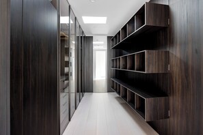 A modern hallway with built-in shelving units and a glass partition.
