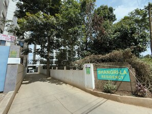 Una entrada cerrada con reja a Shangri-La Residency, con un letrero que indica el nombre.