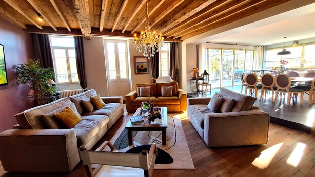 A spacious living room with wooden flooring, a chandelier, and a large window. - Domaine de la Francoise (Dieulefit)