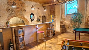 A bar area with stools, a pool table, and a brick wall. - Domaine de la Francoise (Dieulefit)