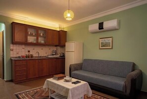 Apartamento básico | Cozinha privada | Geladeira, cooktop, talheres/pratos/utensílios de cozinha