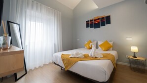 Een hotelkamer met een bed, een bureau, een lamp en kunst aan de muur.