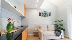 Een moderne keuken met een zwart aanrecht, een groene vaas en een gootsteen.