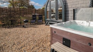 Un jacuzzi, mobiliario exterior y un espacio cubierto con vistas al cielo.